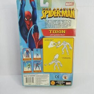 Puede incluir: La parte trasera de un paquete de figuras de acci&oacute;n de Marvel "The Amazing Spider-Man". El paquete presenta un gr&aacute;fico de Spider-Man azul y rojo, con la palabra "Toxin" en rojo y amarillo. El paquete tambi&eacute;n incluye im&aacute;genes de otros personajes.