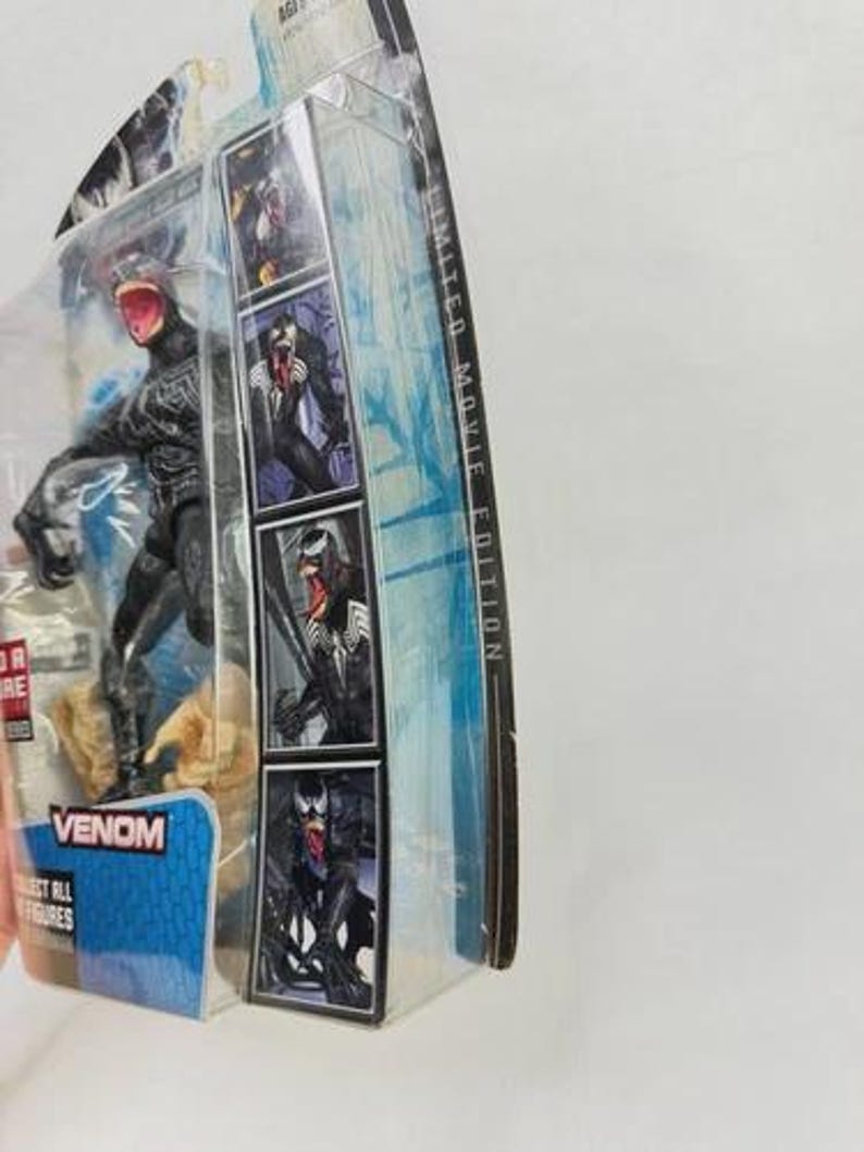 May include: A Venom action figure in a clear plastic package. The figure is black with a red mouth and is posed on a rocky base. The packaging includes images of Venom and the text "Venom" and "Collect All Figures". The package is labeled "Limited Movie Edition".