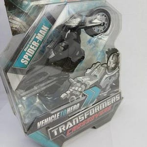 Puede incluir: Figura de acci&oacute;n de Marvel Spider-Man con traje negro, empaquetada como un juguete crossover Vehicle to Hero Transformers. El embalaje incluye el logotipo de Marvel y el nombre de Spider-Man.