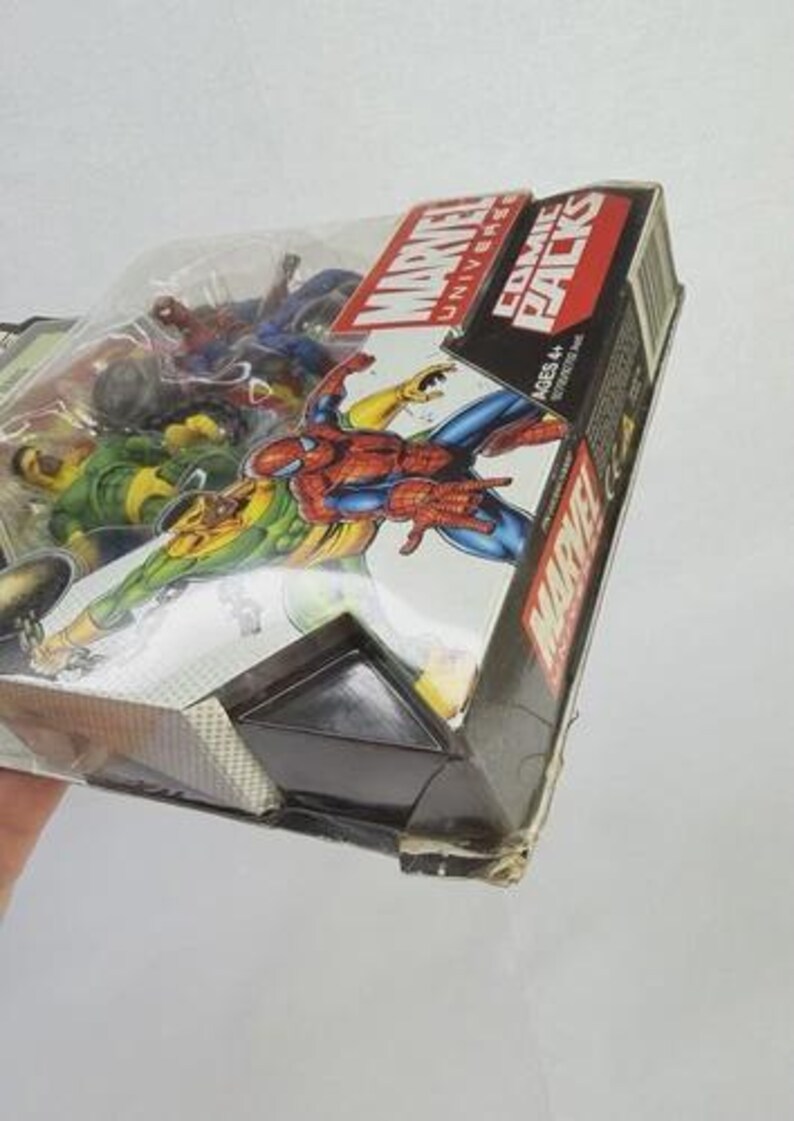 K&ouml;nnte beinhalten: Ein Marvel Universe Comic Packs Box-Set mit Actionfiguren von Spider-Man und anderen Charakteren. Die Verpackung ist schwarz und rot mit dem Marvel-Logo und Charakterillustrationen. Die Figuren sind durch ein transparentes Kunststofffenster sichtbar.