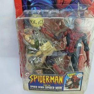 Peut inclure: Figurine articul&eacute;e de Spider-Man dans un emballage plastique transparent. La figurine est rouge et noire, avec un costume d&eacute;taill&eacute;. L'emballage porte l'inscription "SPIDER-MAN" et "SPIDER-SENSE SPIDER-MAN".