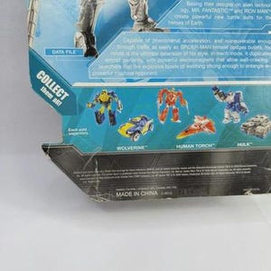 Puede incluir: Un paquete de figuras de acci&oacute;n de juguete con un dise&ntilde;o azul y plateado. El paquete presenta im&aacute;genes de varias figuras de acci&oacute;n, incluyendo a Wolverine, Human Torch y Hulk. El texto "COLLECT them all!" es visible.