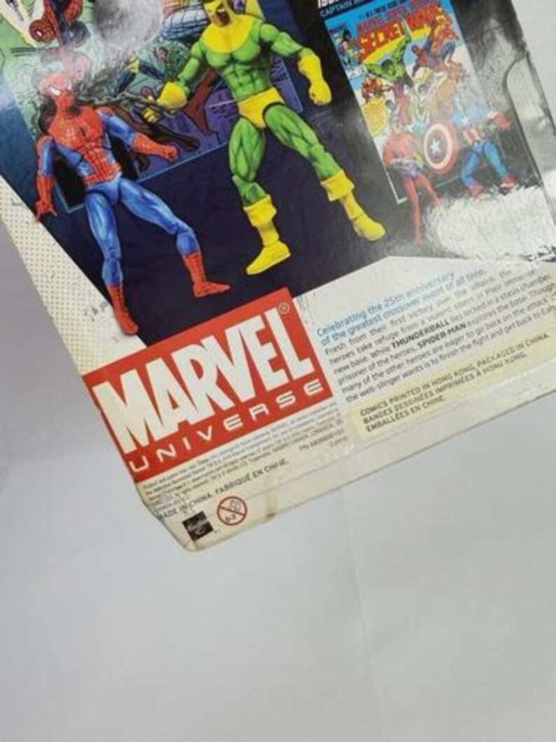 K&ouml;nnte beinhalten: Marvel Universe Actionfigurenverpackung mit Spider-Man und Thunderball. Die Verpackung enth&auml;lt Comic-Kunst und Text. Das Marvel-Logo ist prominent in Rot und Wei&szlig; dargestellt.