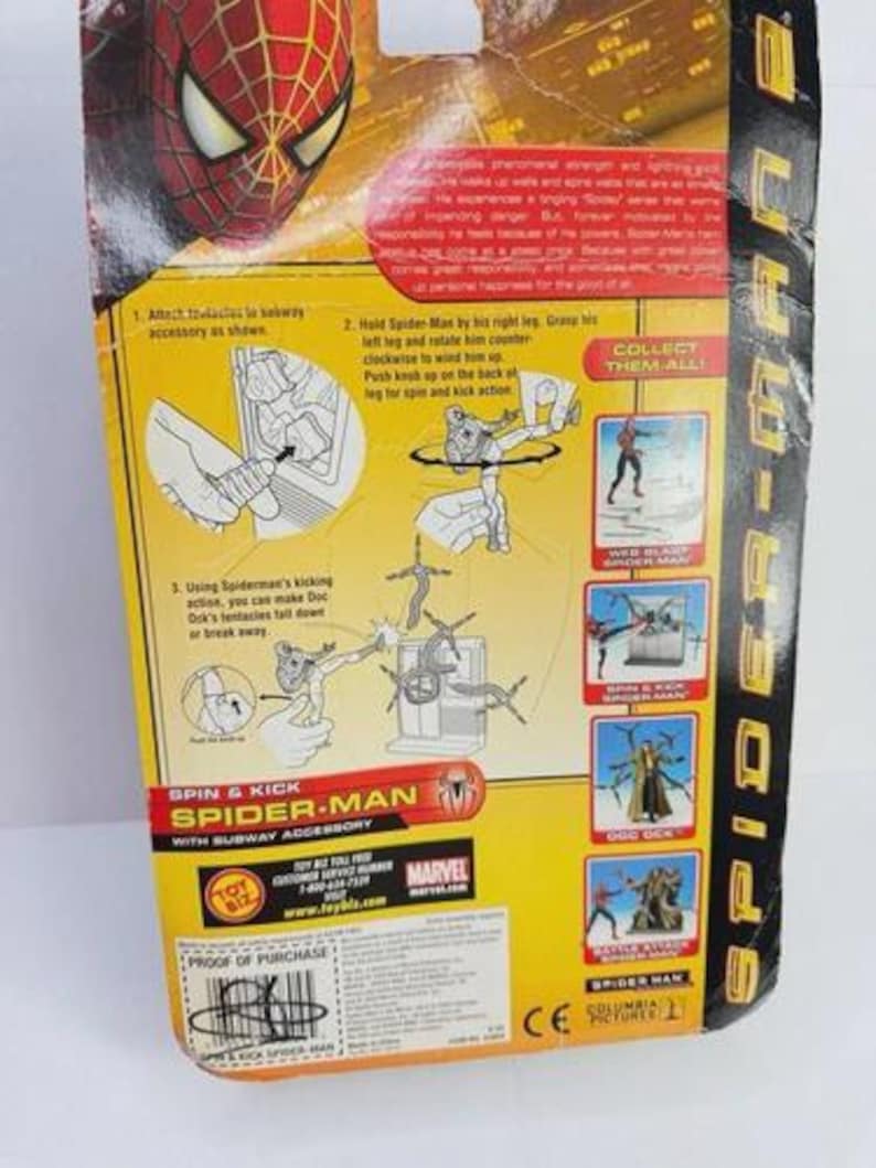 May include: The back of a Spider-Man action figure package. The package is yellow and black, with instructions and images of the action figure. The text on the package includes "Spin & Kick Spider-Man" and "Collect Them All!"