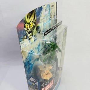 May include: A packaged Green Goblin action figure from the Spider-Man series. The packaging features a dynamic illustration of the character. The figure is visible through a clear plastic window. The packaging is in a clear plastic blister pack.