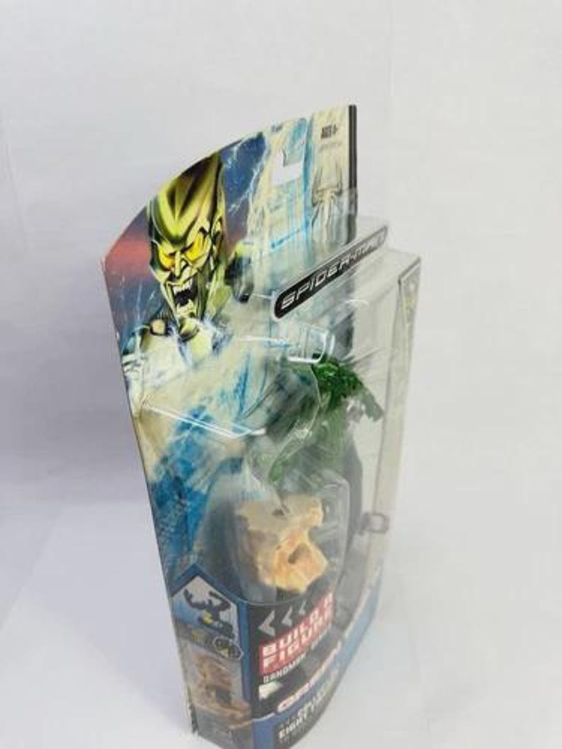 May include: A packaged Green Goblin action figure from the Spider-Man series. The packaging features a dynamic illustration of the character. The figure is visible through a clear plastic window. The packaging is in a clear plastic blister pack.
