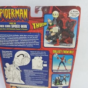 Peut inclure: Emballage de figurine Spider-Man avec le texte "Spider-Man" et "Light-Up Spider-Sense Spider-Man". L'emballage rouge et bleu pr&eacute;sente des images de Spider-Man et d'autres personnages.