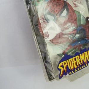 May include: Spider-Man Classics action figure in original packaging. The figure is red, blue, and black, with a detailed Spider-Man mask. The packaging features comic book art and the words "Spider-Man Classics".