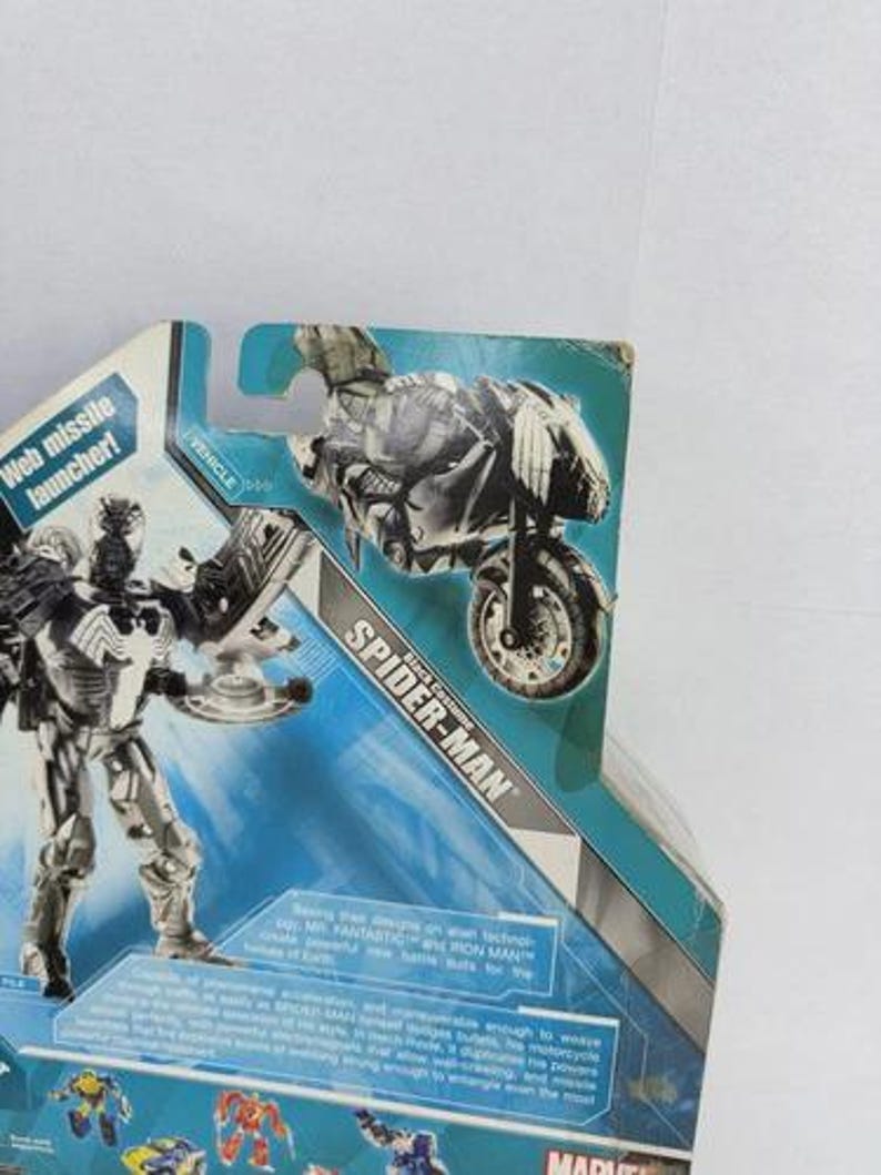 Puede incluir: Figura de acci&oacute;n de Spider-Man en blanco y negro, con una moto. El embalaje incluye el texto "Web missile launcher!" y "Spider-Man". Producto Marvel.