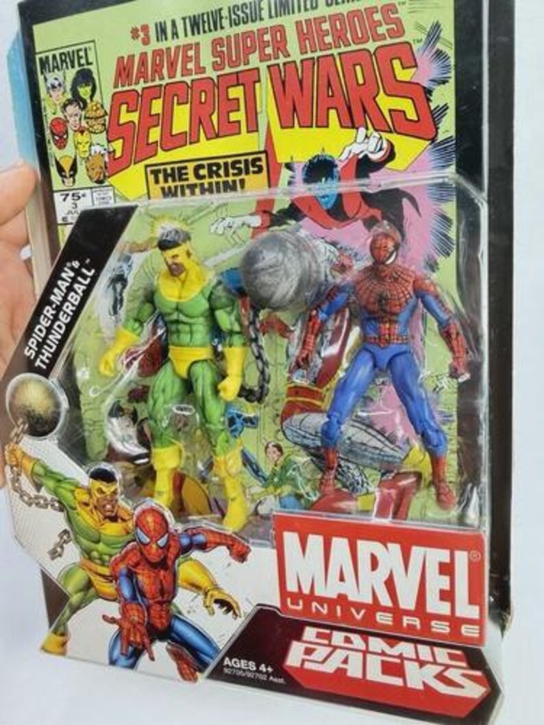 K&ouml;nnte beinhalten: Marvel Universe Comic Packs mit Spider-Man und Thunderball Actionfiguren. Die Verpackung enth&auml;lt Comic-Kunst mit dem Titel "Secret Wars" und dem Marvel-Logo. Die Figuren sind in leuchtenden Farben gehalten.