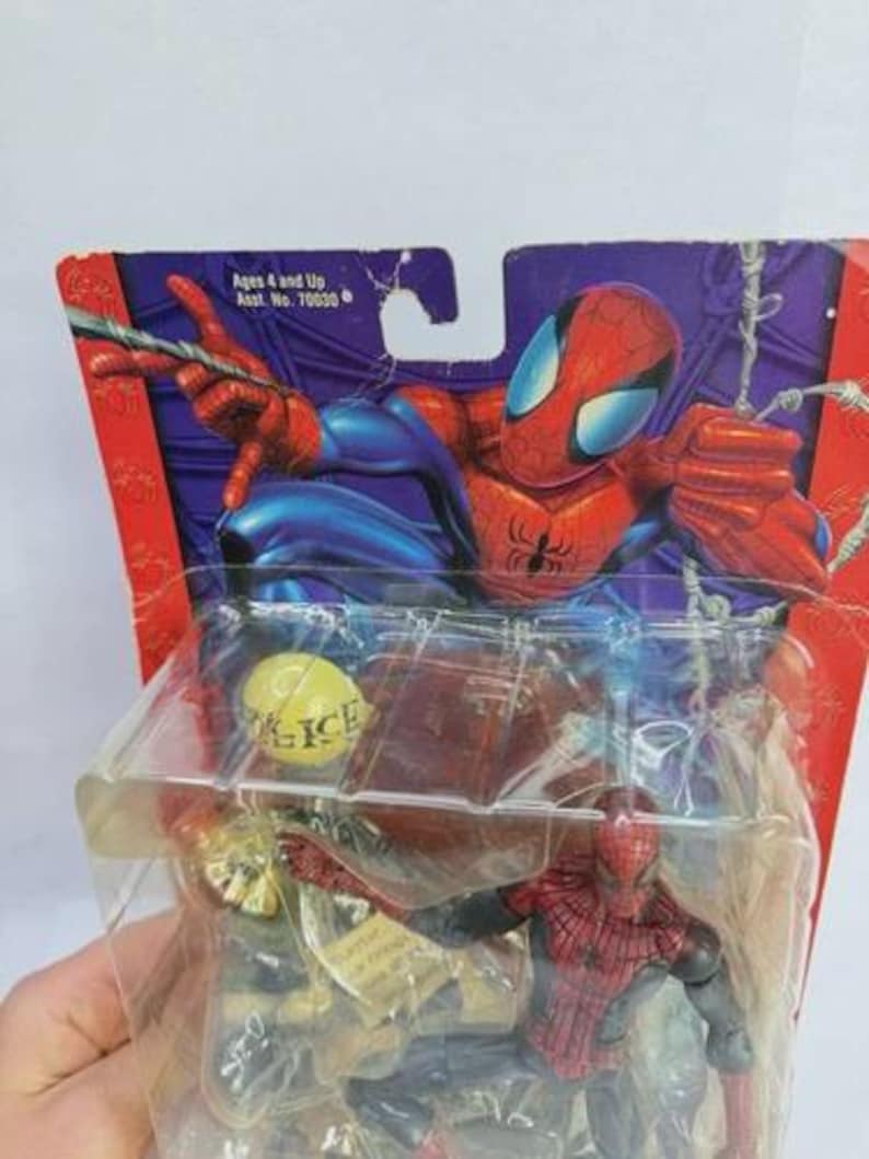 Peut inclure: Figurine articul&eacute;e de Spider-Man dans son emballage d'origine. La figurine est rouge et noire, avec un costume d&eacute;taill&eacute;. L'emballage pr&eacute;sente une illustration de Spider-Man et le texte "Ages 4 and Up".