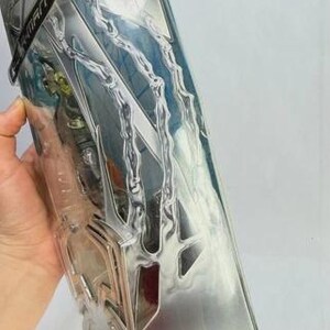 May include: A silver-colored plastic action figure package with a clear front. The package has a stylized design with lightning bolt-like shapes and the word "SPIDER-MAN" on a black label. The package is partially visible.