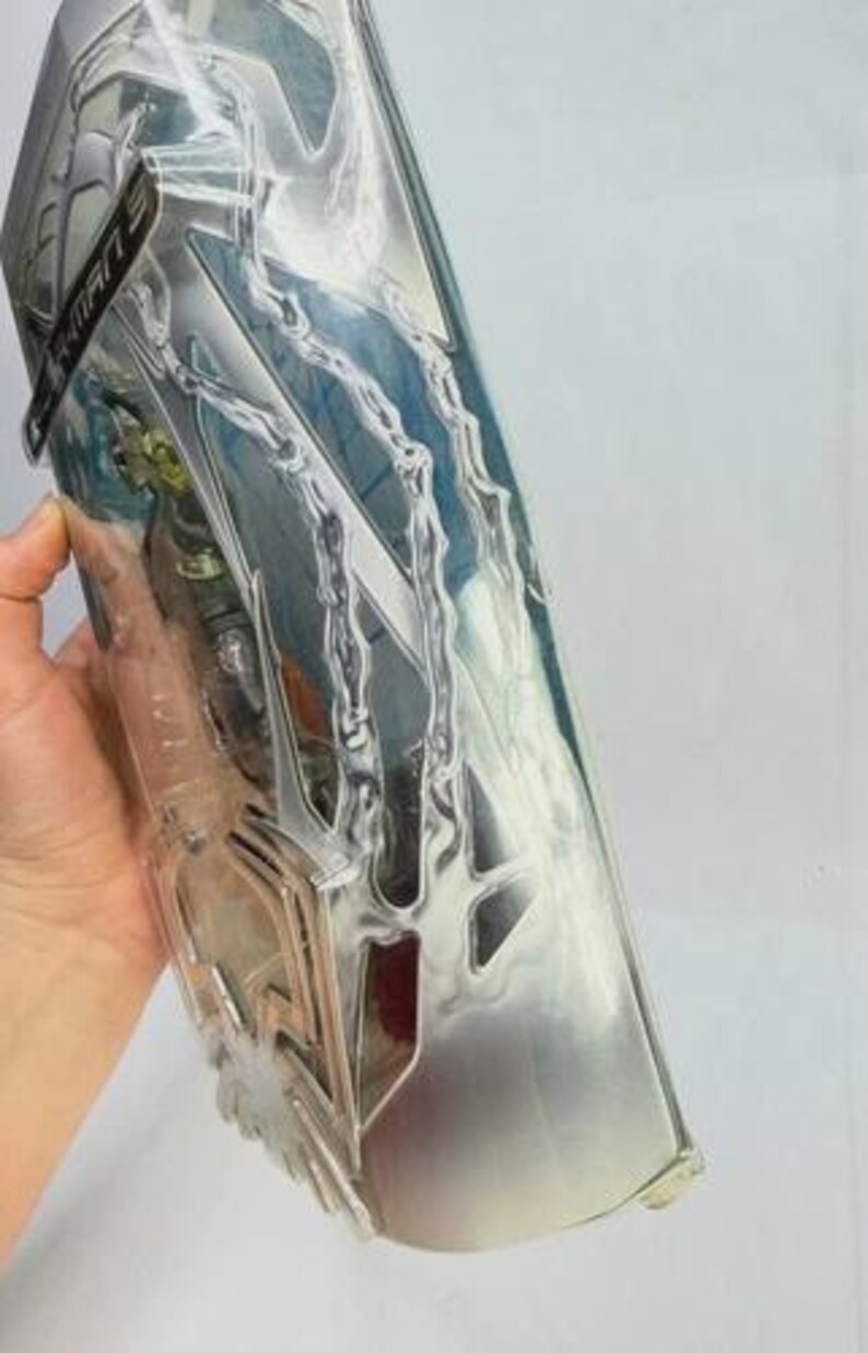 May include: A silver-colored plastic action figure package with a clear front. The package has a stylized design with lightning bolt-like shapes and the word "SPIDER-MAN" on a black label. The package is partially visible.