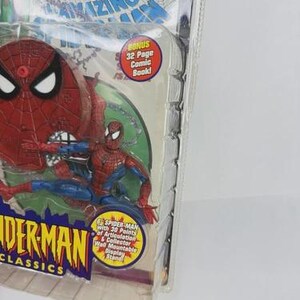 May include: Spider-Man action figure in a clear plastic package. The figure is red and blue, with a red spider-web design on the head. The packaging includes text that reads "Spider-Man Classics" and "Bonus 32 Page Comic Book!"