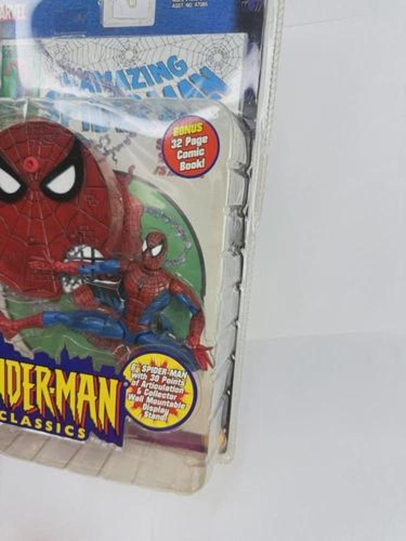 May include: Spider-Man action figure in a clear plastic package. The figure is red and blue, with a red spider-web design on the head. The packaging includes text that reads "Spider-Man Classics" and "Bonus 32 Page Comic Book!"