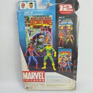 K&ouml;nnte beinhalten: Marvel Universe Actionfigur-Verpackung mit Spider-Man und Thunderball. Die Verpackung enth&auml;lt Comic-Kunst aus Secret Wars, Ausgabe Nr. 2 und Ausgabe Nr. 1. Die Verpackung ist blau und wei&szlig; mit dem Marvel-Logo.