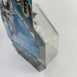 Puede incluir: Una figura de acci&oacute;n de Spider-Man en un paquete de pl&aacute;stico transparente. El embalaje tiene un dise&ntilde;o azul y blanco con las palabras "Spider-Man" impresas. La figura es parcialmente visible.