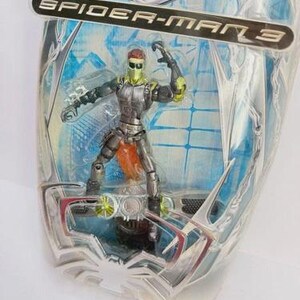 May include: Spider-Man 3 action figure of the Green Goblin in a sealed package. The figure is in a dynamic pose, wearing a green and silver suit with orange accents. The packaging features the Spider-Man 3 logo.