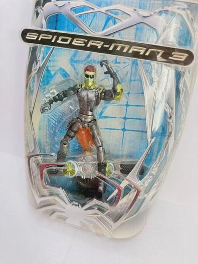 May include: Spider-Man 3 action figure of the Green Goblin in a sealed package. The figure is in a dynamic pose, wearing a green and silver suit with orange accents. The packaging features the Spider-Man 3 logo.