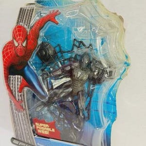 Peut inclure: Figurine Spider-Man dans un emballage plastique transparent. La figurine est noire et argent&eacute;e, avec un graphisme Spider-Man rouge et bleu sur l'emballage. L'emballage comprend le texte "Spider-Man 3" et "Super Posable Web!"