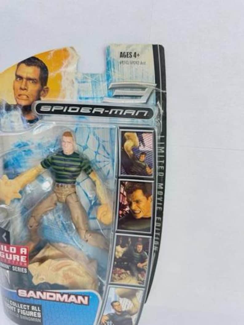 May include: Spider-Man Sandman action figure in original packaging. The figure wears a green and black striped shirt and tan trousers. The packaging includes images of the character and the text "Limited Movie Edition". Ages 4+