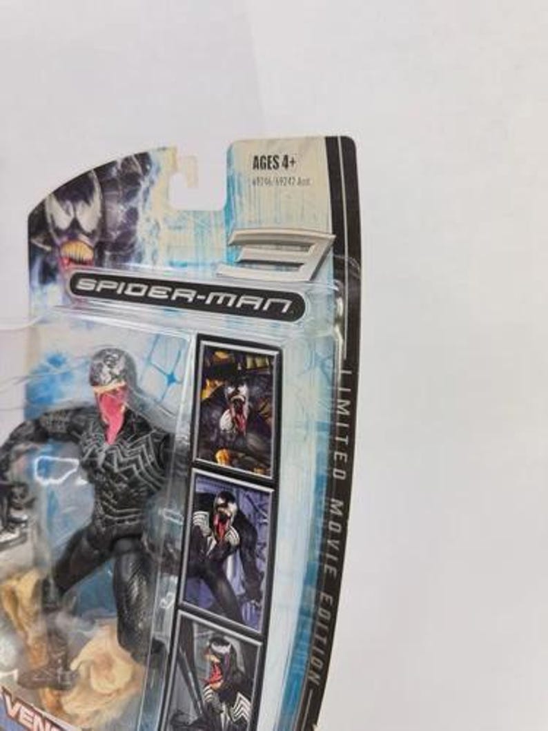 May include: A Spider-Man action figure of Venom, a black and white character with a pink tongue, in a plastic package. The package includes the text "Spider-Man" and "Limited Movie Edition". The age range is Ages 4+.