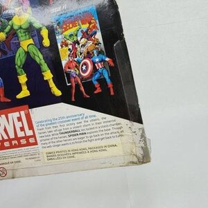 K&ouml;nnte beinhalten: Marvel Universe Actionfigurenverpackung mit Comic-Illustrationen und Superhelden-Actionfiguren. Der Verpackungstext feiert das 25-j&auml;hrige Jubil&auml;um eines Crossover-Events. Die Figuren umfassen Spider-Man, Captain America und andere.