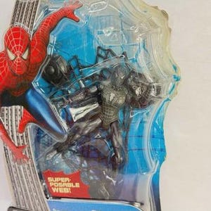 Peut inclure: Figurine articul&eacute;e Spider-Man 3 dans un emballage plastique transparent. La figurine comprend un autocollant &agrave; d&eacute;coller. L'emballage porte les mentions "Super Posable Web!" et "Super-articul&eacute; avec toile suspendue!"
