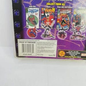 May include: Sealed Spider-Man action figure packaging. The packaging features comic book art of Spider-Man and Venom. The text on the packaging includes "COLLECT THEM ALL" and "PROOF OF PURCHASE".