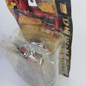 May include: Sealed Spider-Man action figure in original packaging. The figure is red and blue, with a black web design. The packaging is a cardboard backing with a clear plastic front, featuring the Spider-Man logo and character art.