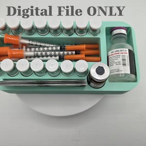 May include: A light green rectangular organizer tray containing multiple small glass vials with white caps, several orange-capped syringes, a larger glass bottle with a purple cap, and a small dark vial. The text Digital File ONLY is visible.