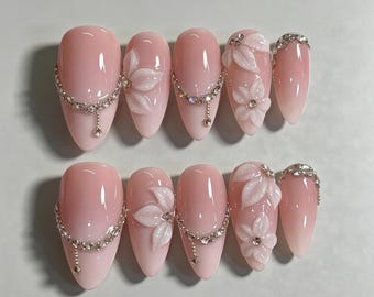 Unhas postiças personalizadas com corrente de strass e flor 3D em degradê rosa, formato amendoado médio, unhas de luxo para noivas, perfeitas para casamentos e encontros românticos.