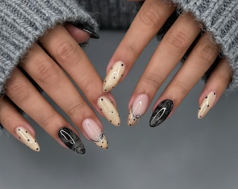 Unhas Postiças Personalizadas | Unhas pintadas à mão em tons de bege e preto com bolinhas, um design chique com detalhes de laço.