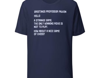 Könnte beinhalten: Marineblaues T-Shirt mit weißem Text. Der Text lautet: "GREETINGS PROFESSOR FALKEN, HELLO, A STRANGE GAME. THE ONLY WINNING MOVE IS NOT TO PLAY. HOW ABOUT A NICE GAME OF CHESS?" Ein klassisches Rundhals-T-Shirt.