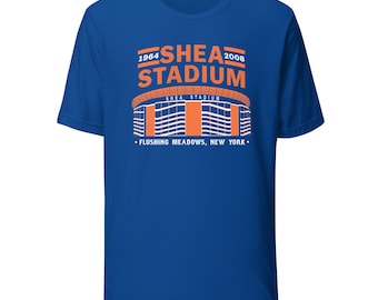 May include: Royal blue t-shirt featuring an orange and white graphic of Shea Stadium, with the years 1964 and 2008. The text "SHEA STADIUM" is above the stadium illustration, and "FLUSHING MEADOWS, NEW YORK" is below.