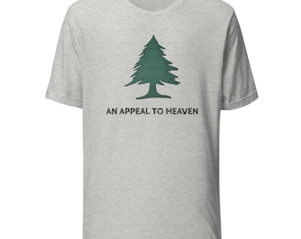 May include: A light gray t-shirt featuring a green pine tree graphic. Below the tree is the text "AN APPEAL TO HEAVEN" in black. The shirt has a crew neck and short sleeves.