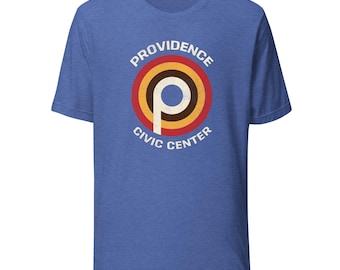 May include: Blue t-shirt featuring a circular graphic with the text "PROVIDENCE CIVIC CENTER." The graphic has a white "P" inside concentric circles of red, brown, and yellow. The shirt is made of a soft material.