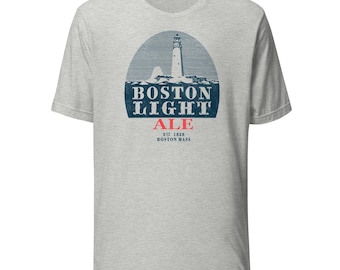 Könnte beinhalten: Hellgraues T-Shirt mit einem marineblauen und roten Grafik eines Leuchtturms und dem Schriftzug "BOSTON LIGHT ALE". Das T-Shirt zeigt auch den Text "EST. 1828 BOSTON MASS".