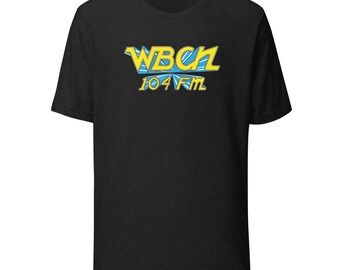 May include: Black t-shirt featuring the text "WBCH 104 FM" in a stylized, blue and yellow design. The shirt is made of a soft material and has a classic crew neck.