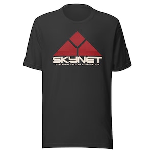 Könnte beinhalten: Schwarzes T-Shirt mit einer rot-weißen Grafik eines Dreiecks mit horizontalen Linien und dem Wort "SKYNET" über "Cyberdyne Systems Corporation" in weißem Text. Das T-Shirt ist aus weichem Material.