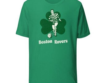 Könnte beinhalten: Grünes T-Shirt mit einem Vintage-Grafik eines Fußballspielers in einem Kleeblatt. Der Spieler trägt ein gestreiftes Trikot und Shorts und schießt einen Fußball. Der Text "Boston Rovers" ist darunter gedruckt.