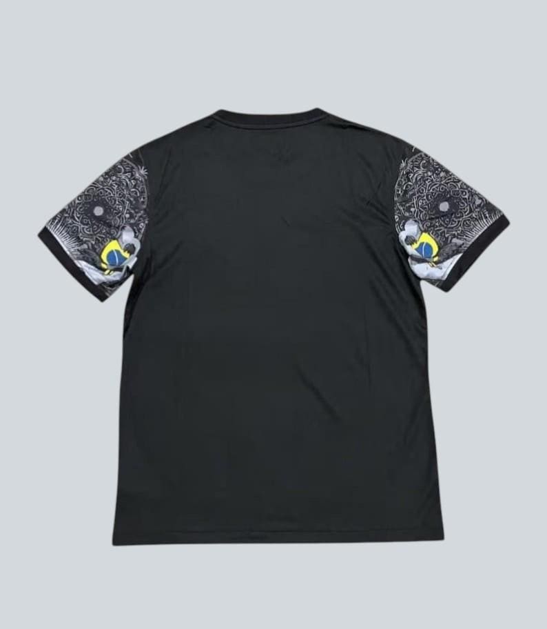 May include: Black short-sleeved t-shirt with patterned sleeves. The sleeves feature a detailed design in shades of gray, white, yellow, and blue. The shirt has a simple, classic crew neck design.