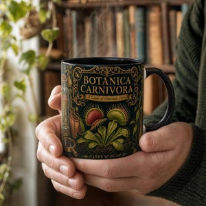 May include: A black ceramic mug featuring a gold and green botanical illustration of Venus flytraps and pitcher plants. The text reads BOTANICA CARNIVORA, A Cabinet of Carnivorous Plants, and CARPE MUSCAM in a decorative, vintage-inspired font style.