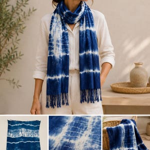 May include: A rectangular scarf featuring a deep blue and white tie-dye pattern with horizontal bands and a fringed edge. The fabric displays a gradient of indigo hues transitioning into white, creating a textured, striped appearance throughout the piece.