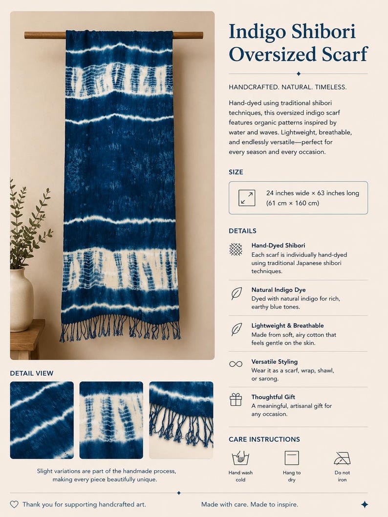 May include: An oversized indigo scarf featuring white shibori patterns, measuring 24 inches wide by 63 inches long. The scarf has a deep blue color with horizontal tie-dye stripes and a fringed bottom edge, displayed hanging from a wooden rod.