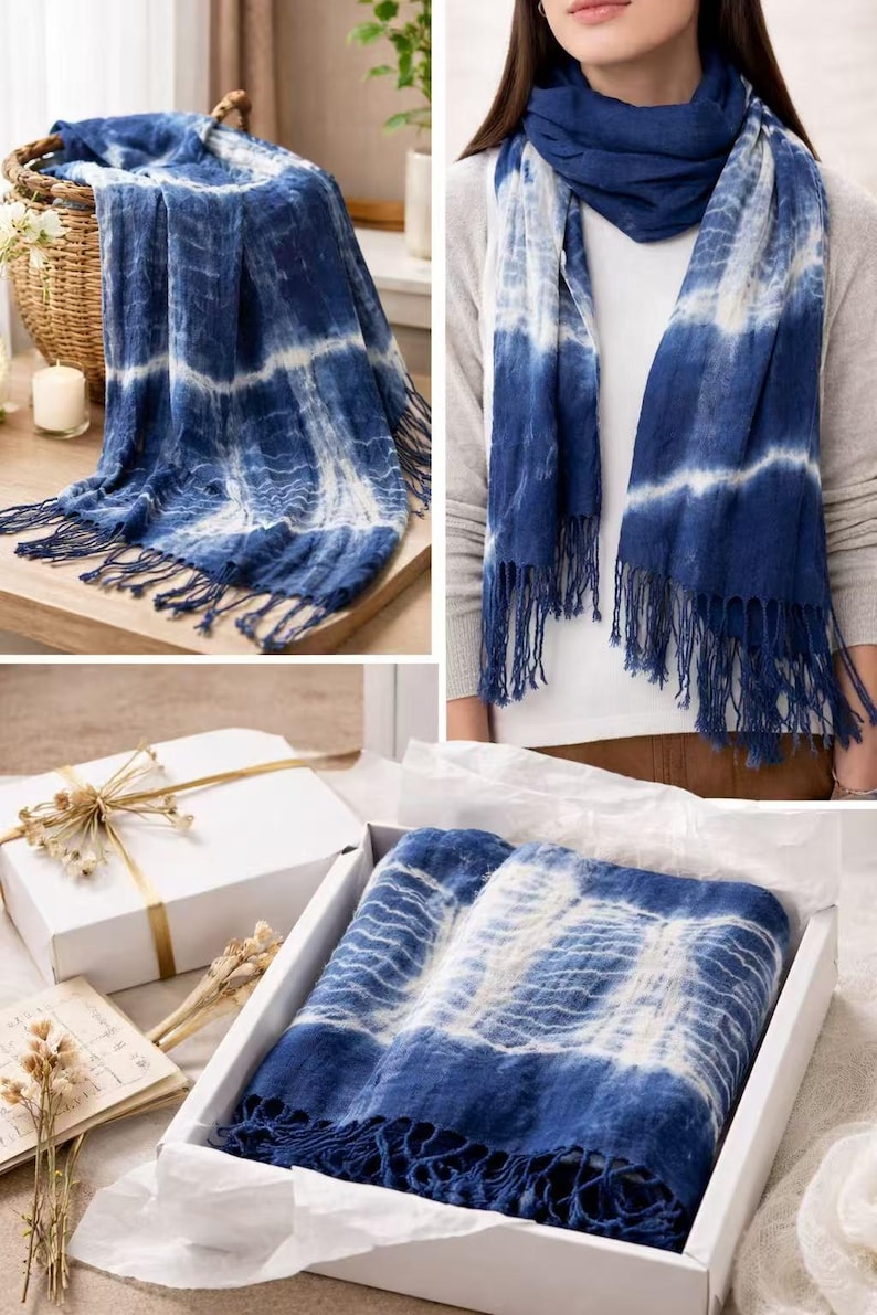 May include: A rectangular scarf featuring a deep blue and white tie-dye pattern with horizontal stripes and fringed edges. The fabric displays a textured appearance with varying shades of indigo and white, finished with long tassels on both ends.