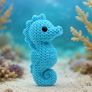 May include: A bright blue knitted seahorse toy featuring a textured surface, a curved tail, a dorsal fin along its back, and a single black bead eye. The object is crafted with a consistent knit pattern and stands upright in a vertical position.
