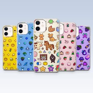 May include: Five phone cases with colourful pixelated designs. The cases feature various patterns, including animals, fruits, and other cute illustrations. The cases are in yellow, blue, cream, pink, and purple.