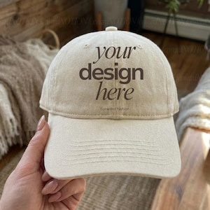 May include: A beige baseball cap with the text "your design here" in a dark brown font. The cap has a curved brim and a button on top. The words "Forward Notion" are below the main text.