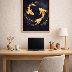May include: A framed artwork featuring two orange koi fish swimming in a circular pattern against a dark blue background. The artwork is displayed on a wooden desk with a laptop, lamp, and other office supplies.